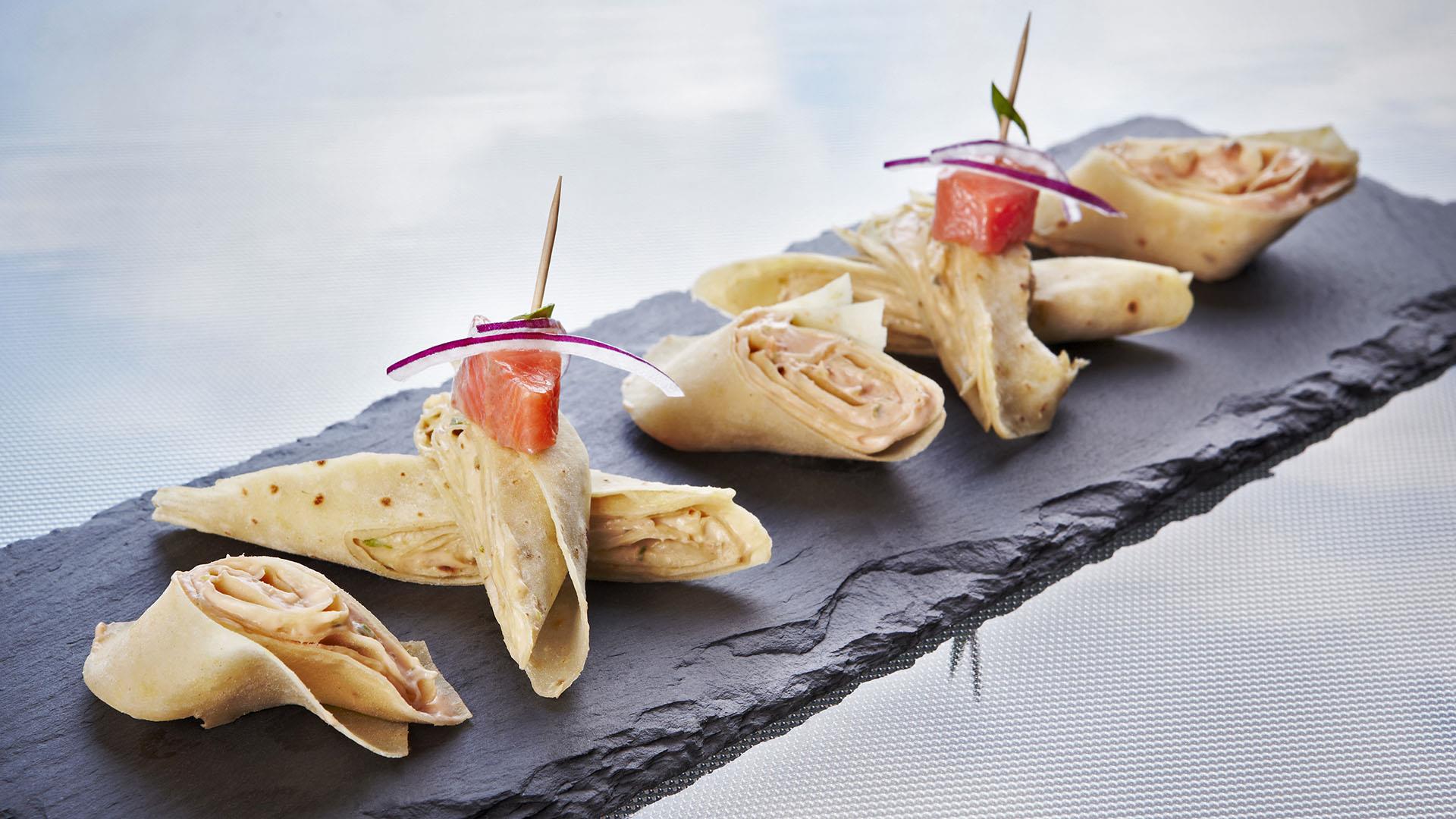 Fermented trout, rakfisk, served in a potato tortilla, nicely laid out on a plate of slate.