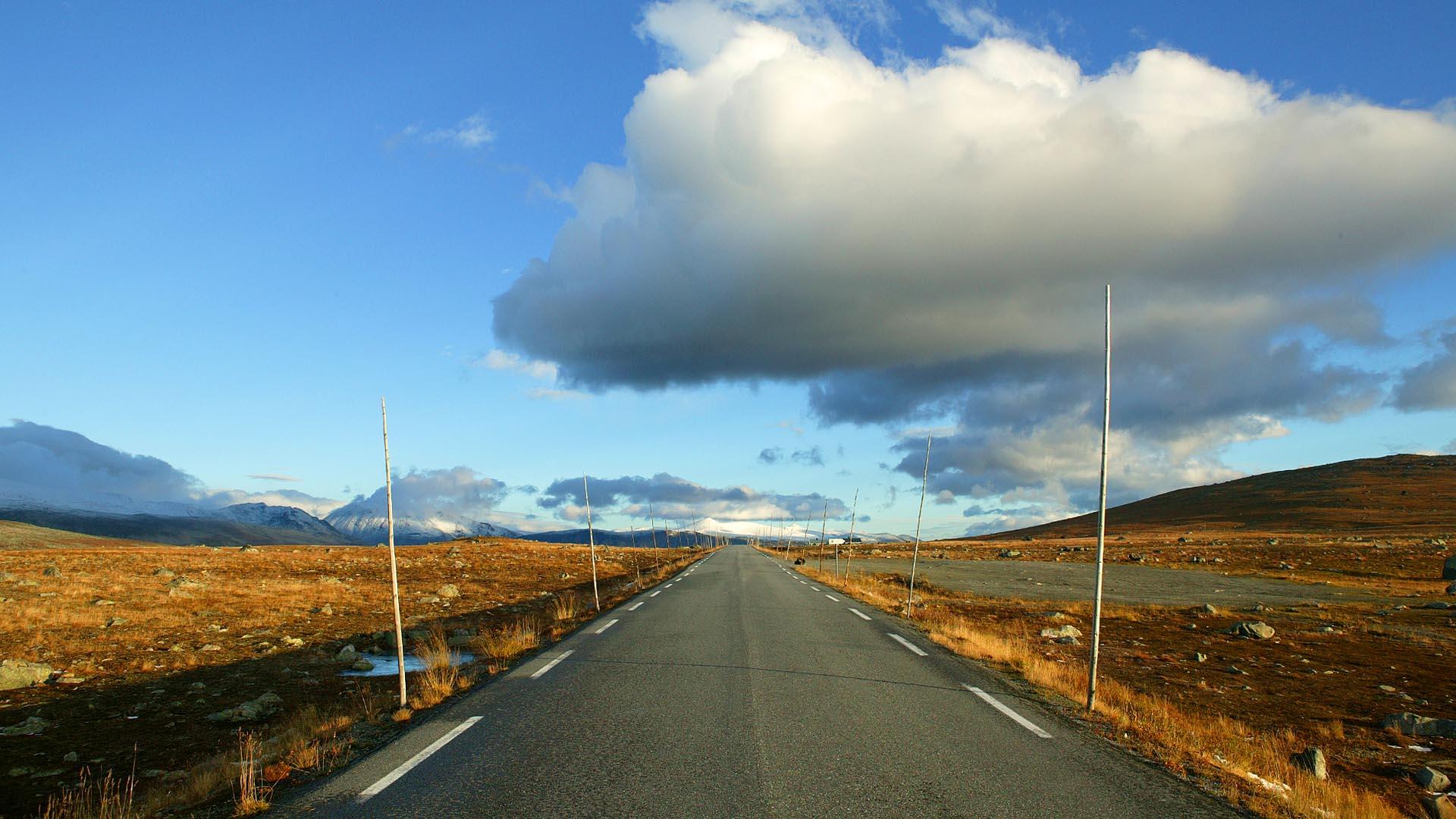 Veien over Valdresflye i midten av bildet med sine karakteriske høye brøytestikker.