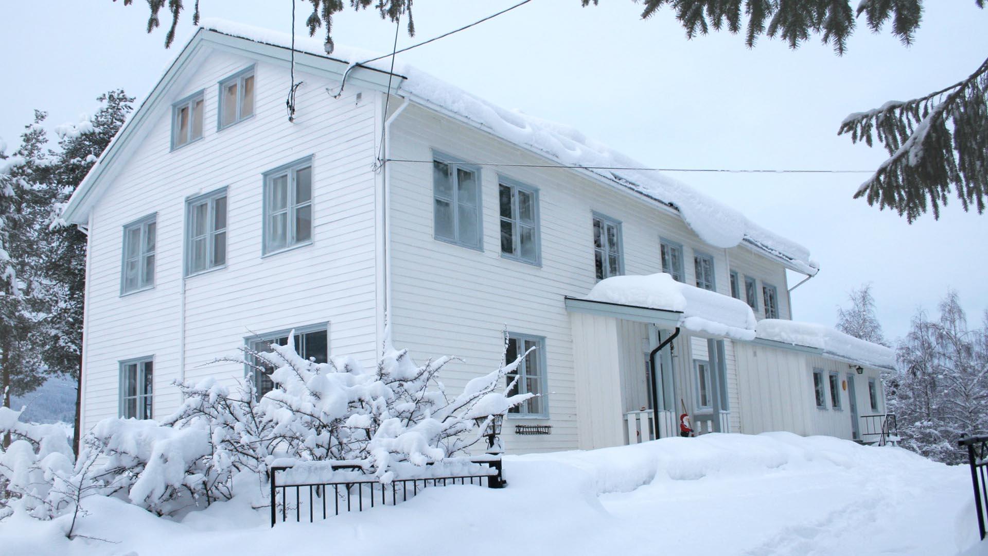 Ein weißes Holzhaus nach Schneefall