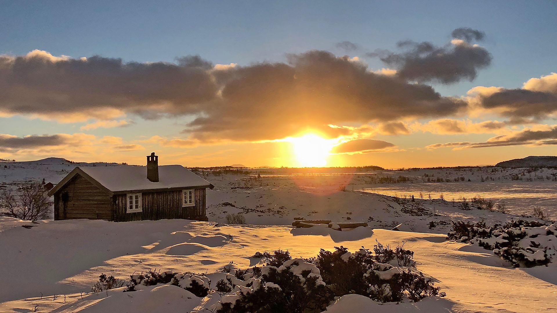 Small farm cabin in the mountains during wintersunset