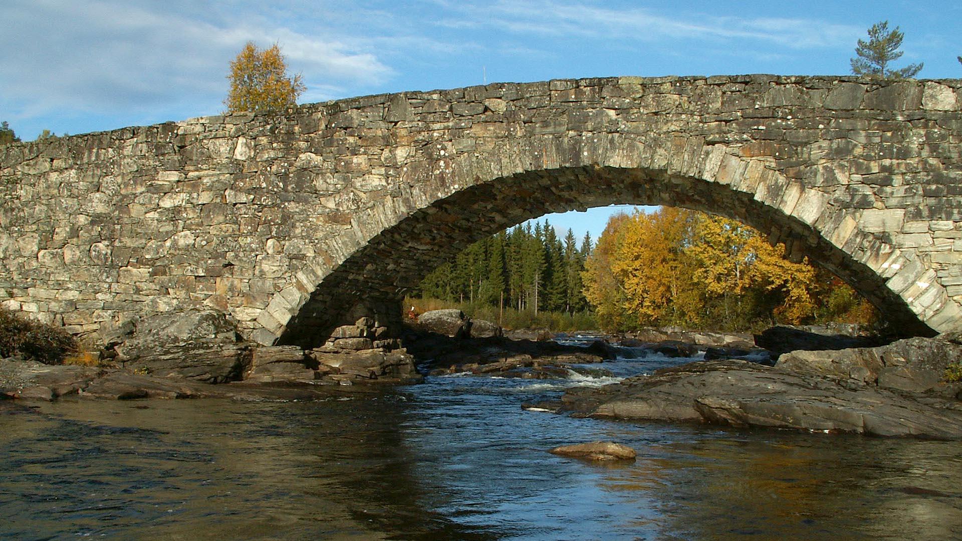 Eine trockengemauerte Steinbrücke über einen Fluss