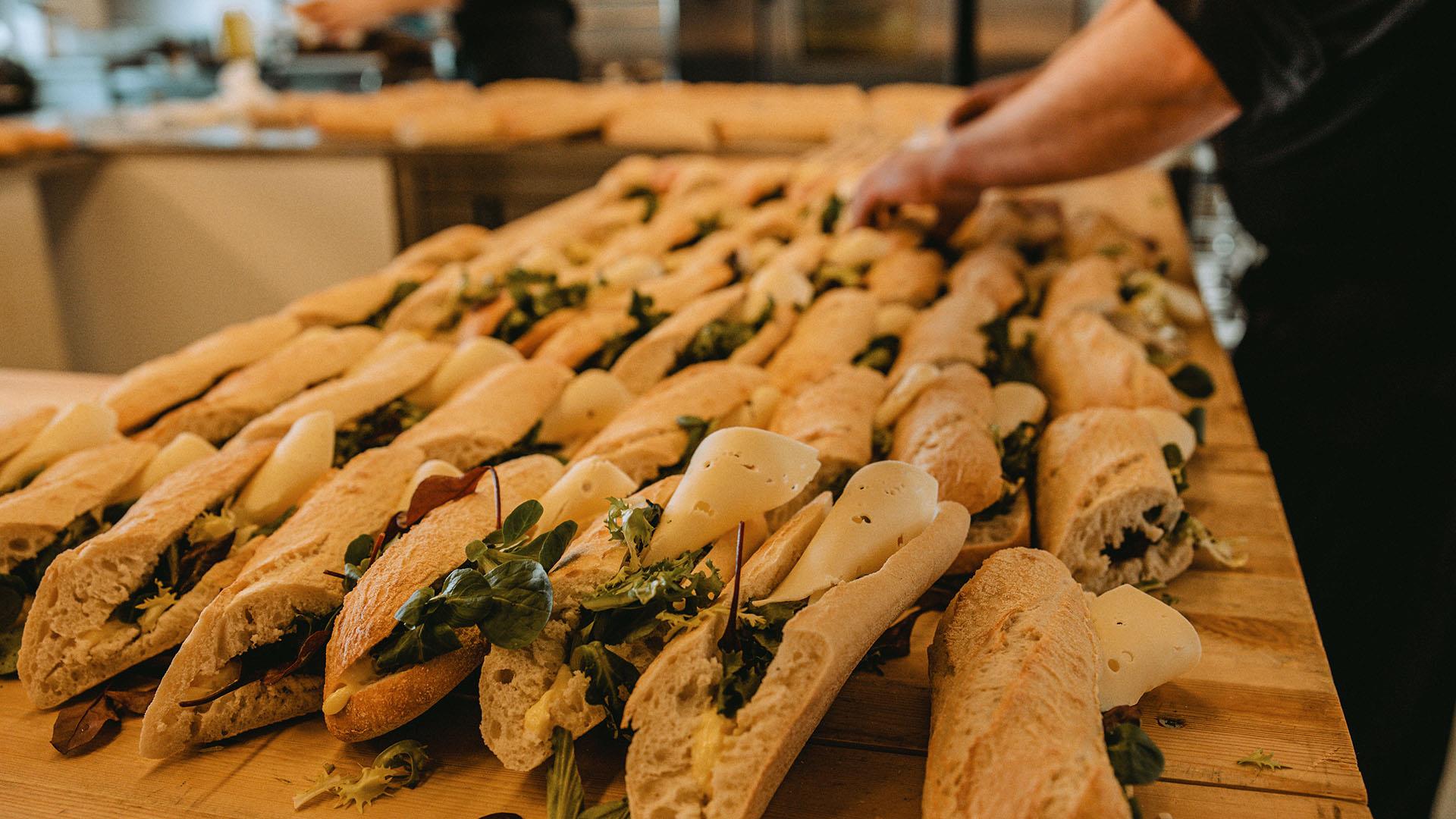 Lots of baguettes are being prepared for a large number of people.