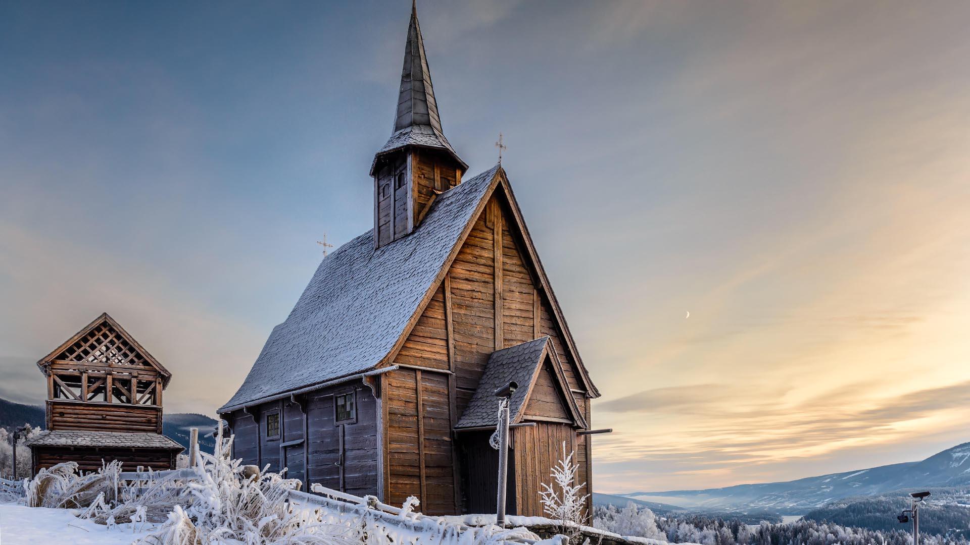 Kald, nærmest skyfri vinterdag med stavkirke midt i bildet