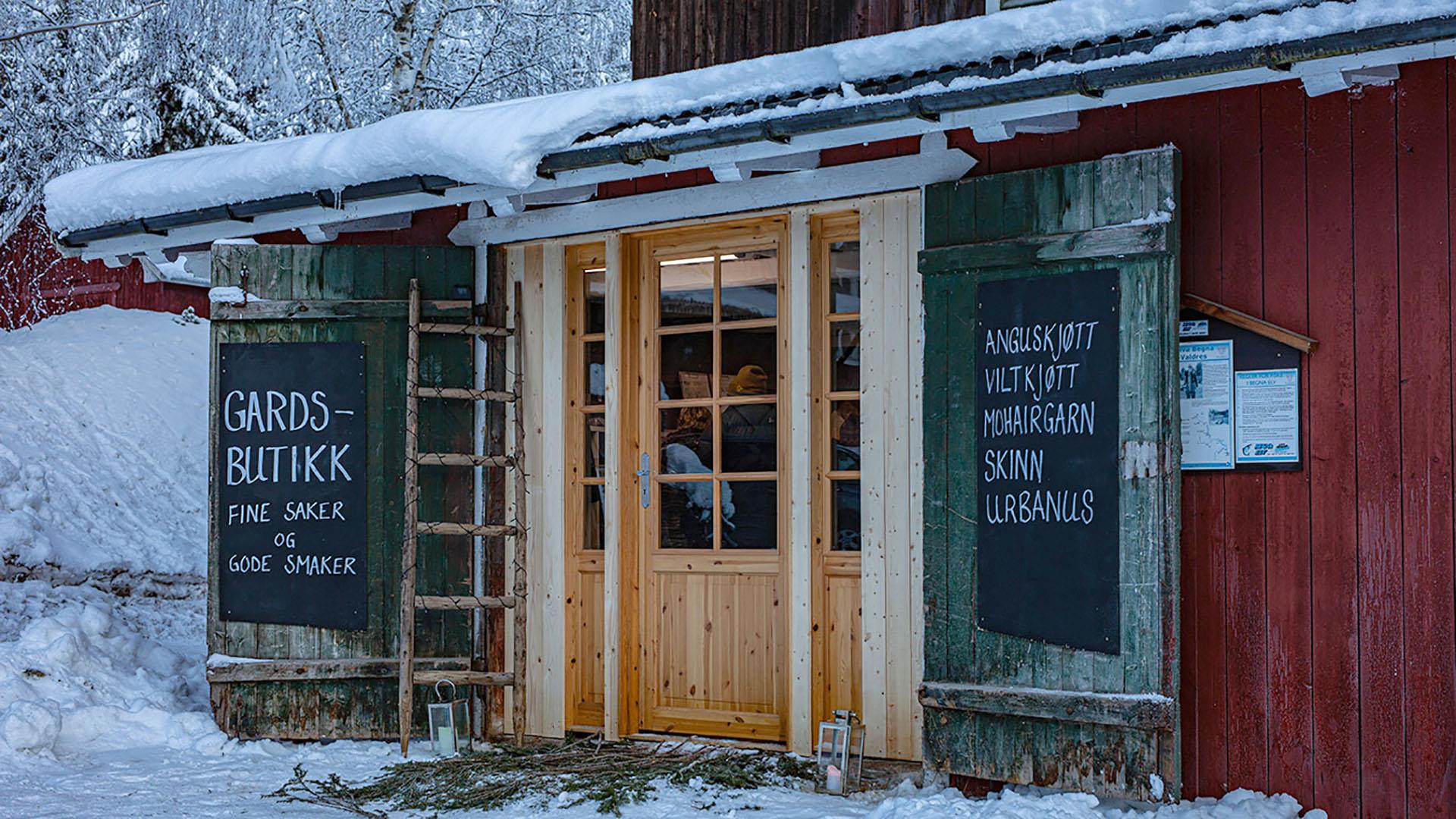 Inngangsdøren til en koselig gardsbutikk på vinteren.