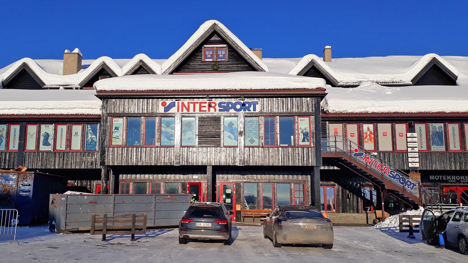 Sportsbutikk over tre etasjer i tjærefarget tre en vinterdag.