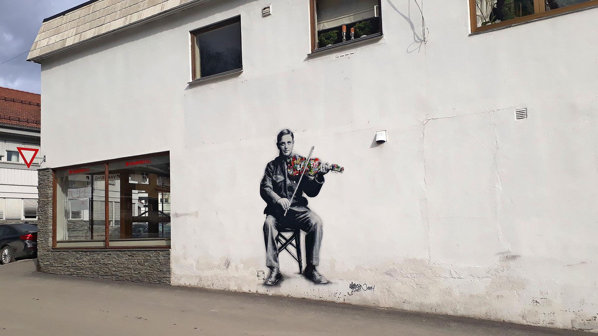 Straßenkunst in Fagernes, die einen Volksmusiker beim Hardangerfiedelspiel zeigt.