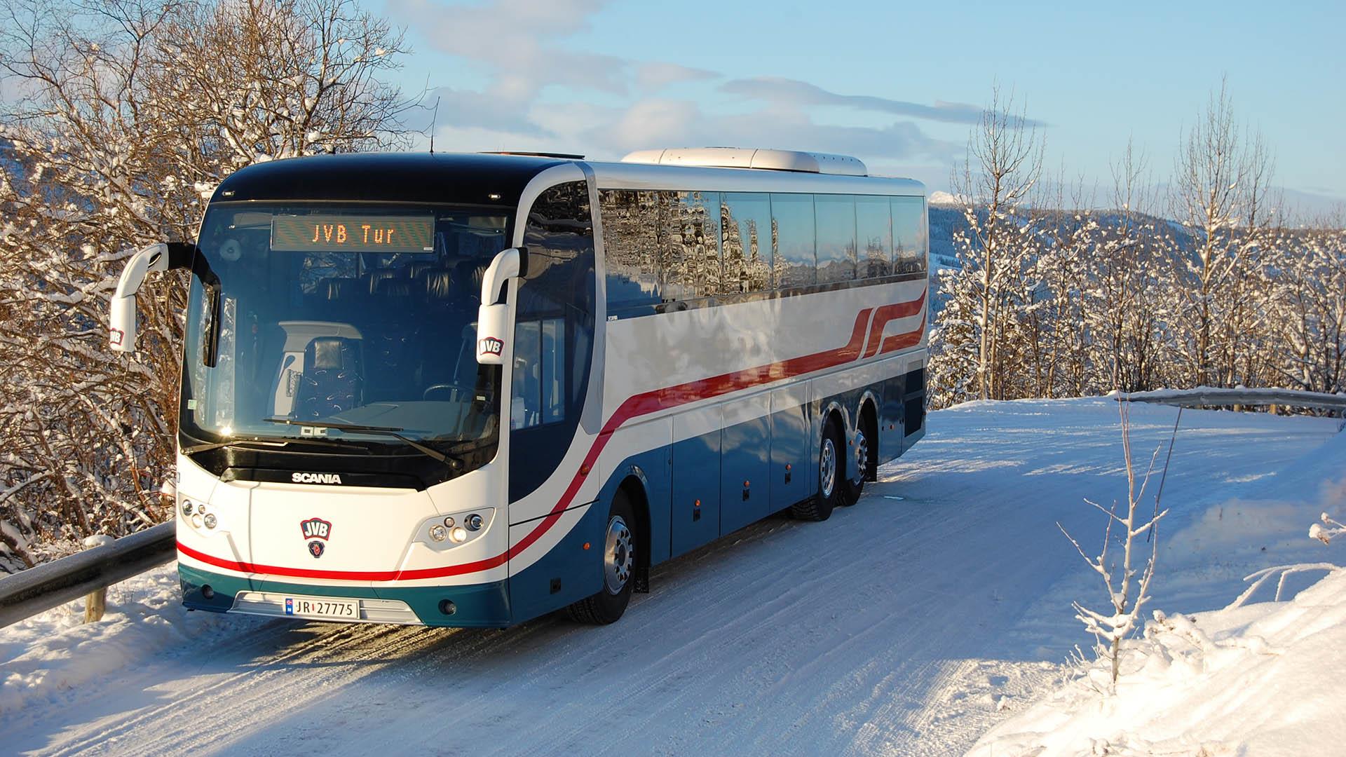 A tour coach in the sunshine on a snowy road