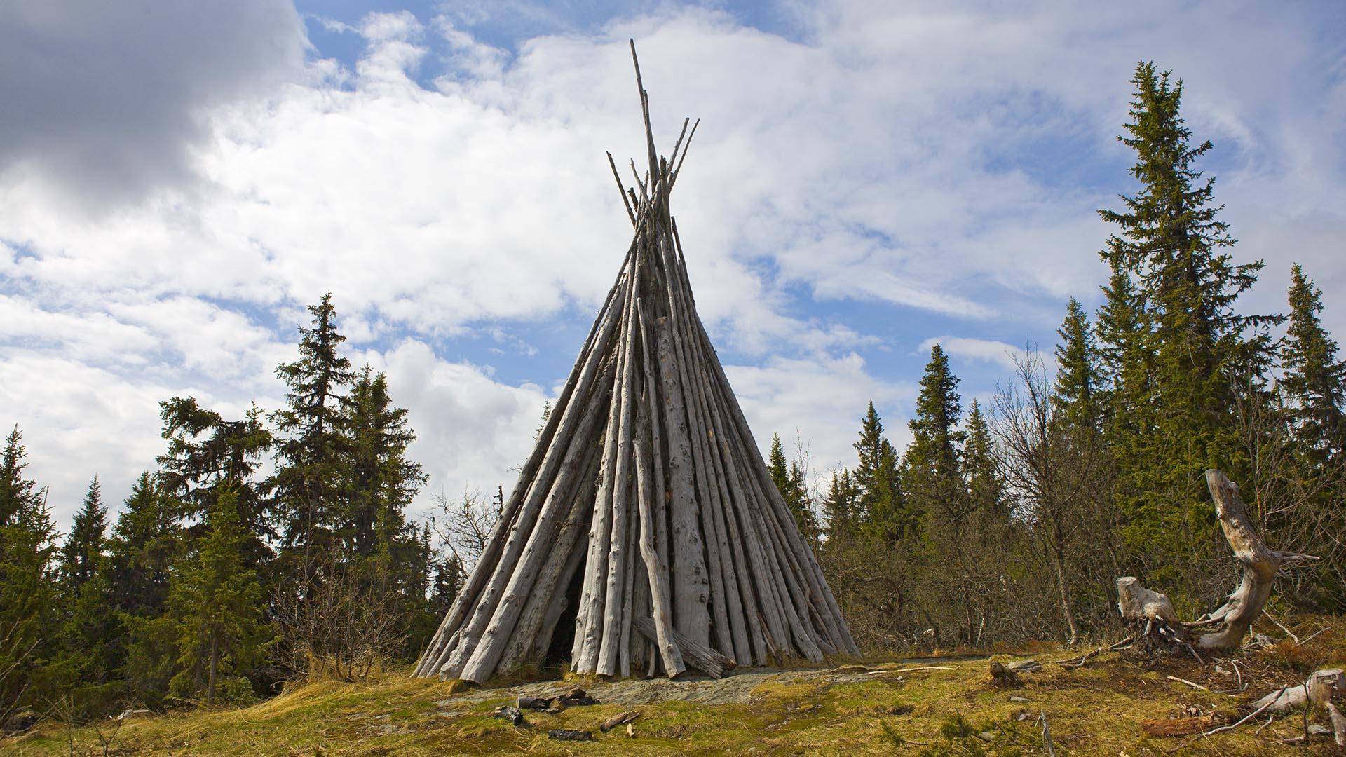 A historical war beacon made from tree trunks piled up against each other like a teepee.