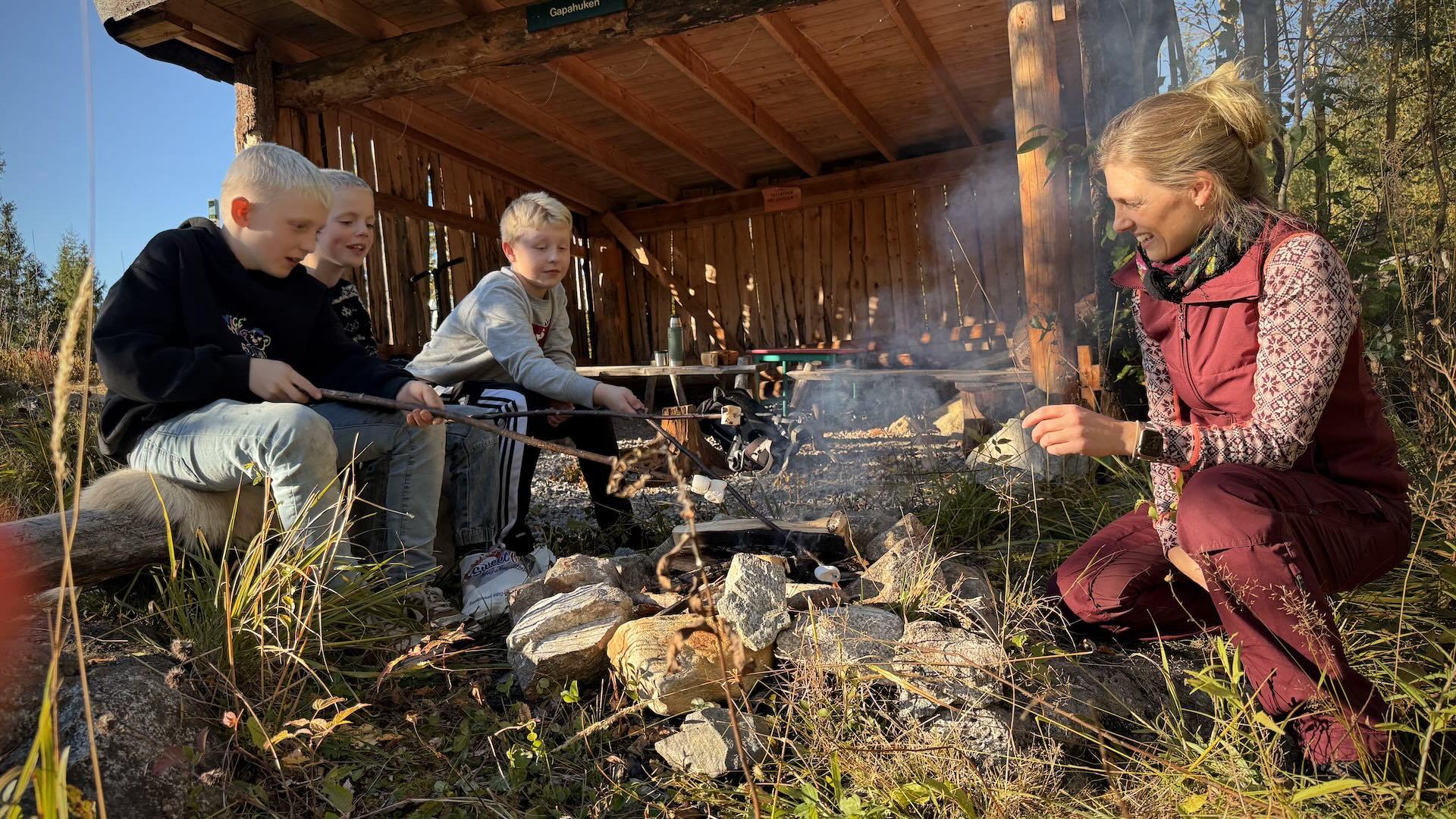 familie er ute og griller ved en gapahuk