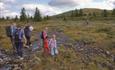 A family hike to Smørlifjellet. A small brook is crossed on rocks.