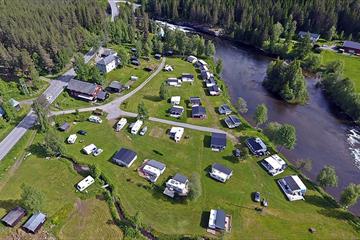 Dronebilde av campingplassen. Idyllisk beliggenhet langs elva.