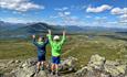 Children enjoy a great view over open mountain terrain with lakes and mountains.