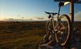 Bicycle at the summit cairn of Gribbe (1057 m.a.s.l.) in the soft light of the evening sun.