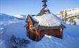 Eine kleine Wärmehütte in Blockbauweise im Schnee