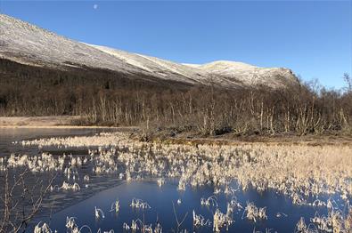 Tidlig høstmorgen ved Matkista. Isen har lagt seg på vannet, og snøen ligger på fjelltoppene.