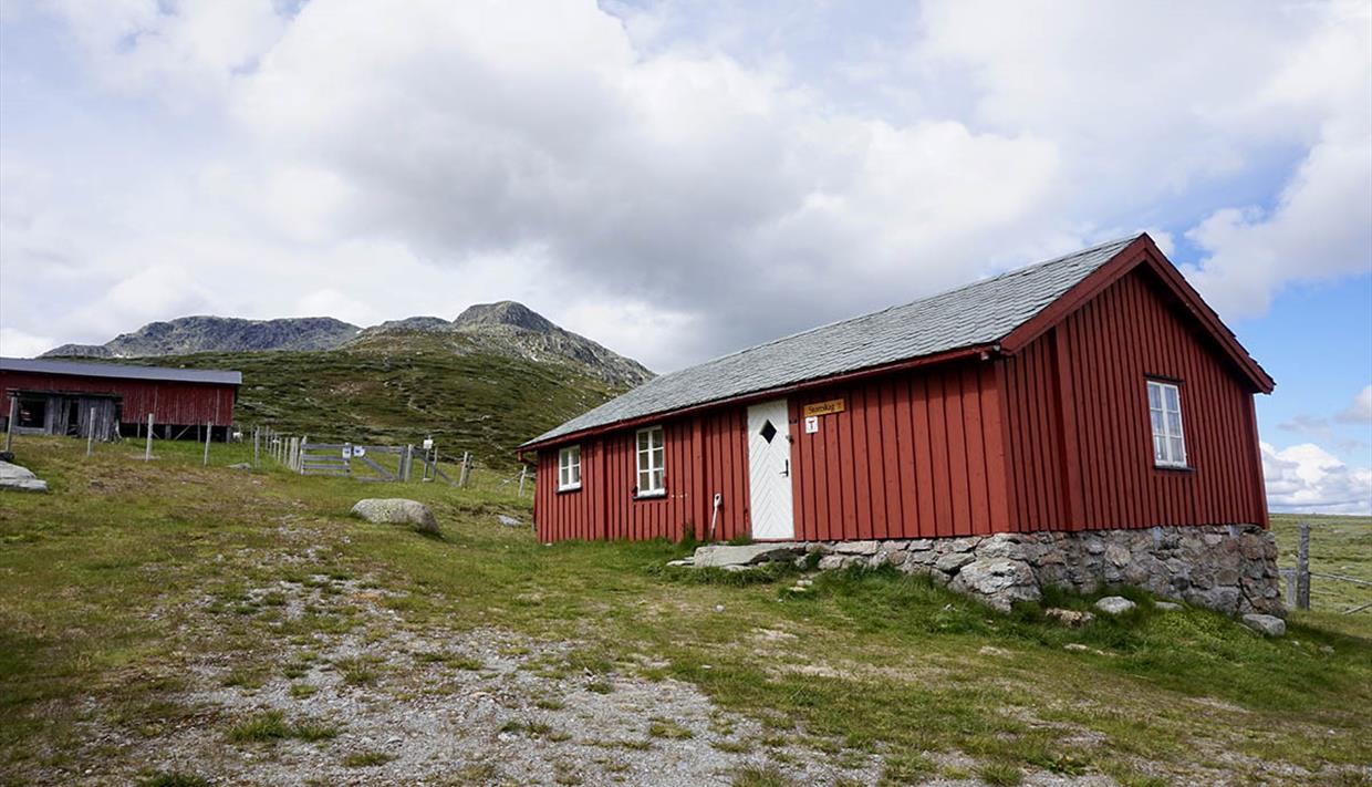 Die rotgemalte DNT-Hütte Storeskag am Fuße des Berges Skaget.