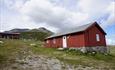 Den røde DNT-hytta Storeskag ved foten av fjellet Skaget.