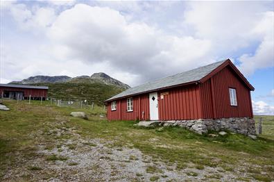 Den røde DNT-hytta Storeskag ved foten av fjellet Skaget.
