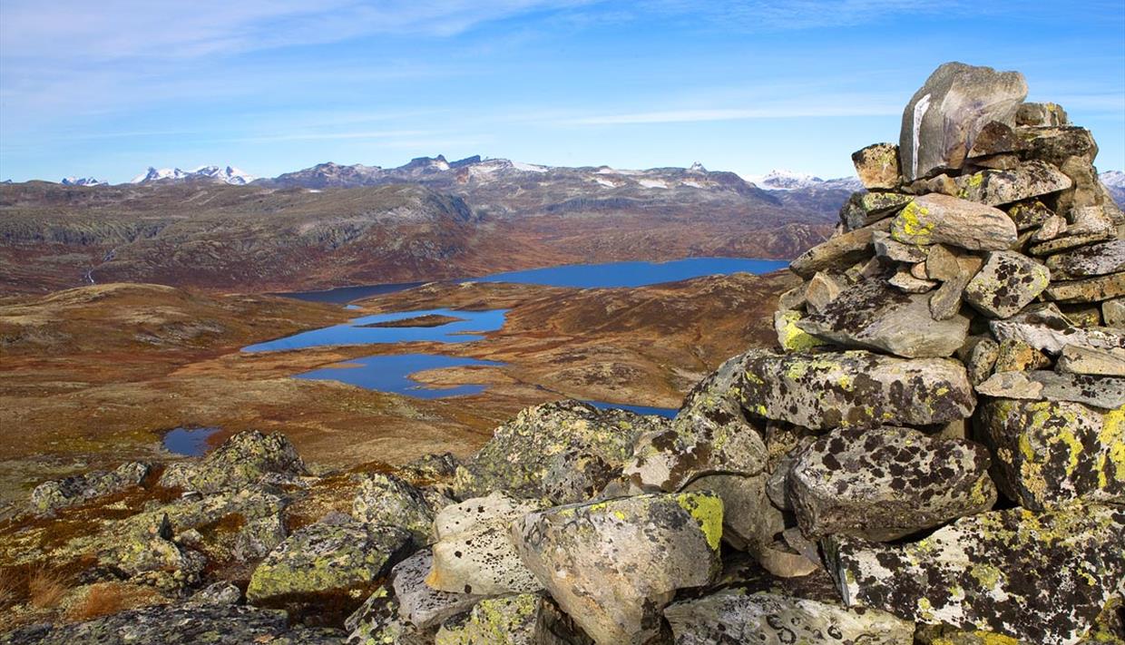 På Tyinstølsnøse med utsikt over vann og fjell mot Hurrunganes spisse tinder i det fjerne.