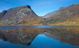 Skutshorn mirrors itsself in the calm water of Lake Vangsmjøse with autumn coloured foothills.