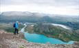 Turgåer på toppen av Besseggen. Utsikt mot fjell og fjord.