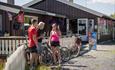 Radfahrer genießen eine Pause und essen Eis in der Sonne vor dem kleinen Kolonialgeschäft und Café in Langestølen.
