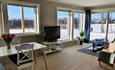 The living room of the apartment "Slettefjell" with large windows and a beautiful view.