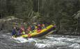 Family rafting on a river with children in the raft
