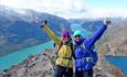 Two happy hikers on a ridge with great mountain views and lakes