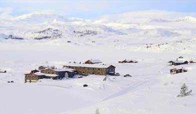 Rødungstøl Høyfjellshotell om vinteren med fantastiske fjell i bakgrunn.