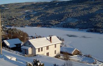 Hovedhuset på Skattebøl fjellgard om vinteren, med utsikt over Strandafjorden.
