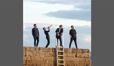 A band standing atop a wall