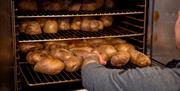 Hot jacket potatoes coming out of the oven at Keighley Market.