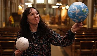 Woman holding a globe and moon in Bradford Cathedral.