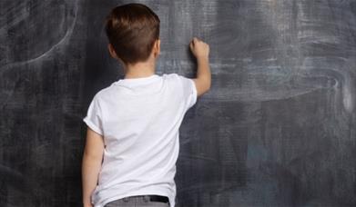 Child writing on a chalk board