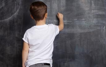 Child writing on a chalk board