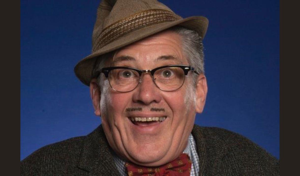 A picture of the character Count Arthur Strong, wearing his trilby at a jaunty angle, and smiling