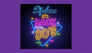 A neon sign in pinks, blues and purples advertising Dylans Back to the 80s show