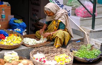 Indian woman sorting food in baskets