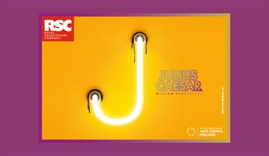 A picture of a neon light in the shape of a huge J, next to the name Julius Caesar