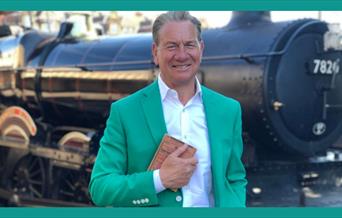A picture of Michael Portilllo, standing in front of a stream engine