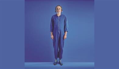 A picture of the comedian Paul Foot, dressed in blue, against a blue background
