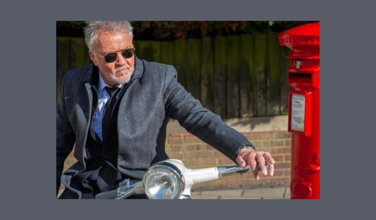 A picture of Paul Young, with a moped