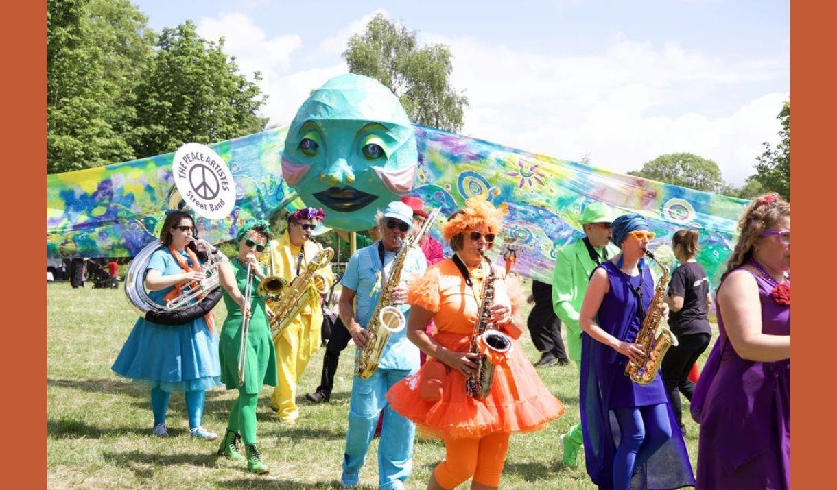 A picture of musicians in colourful clothing, in a park