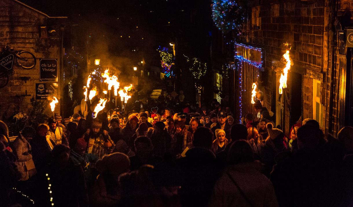 Crowds at Main Street Haworth illuminated by torchlights.