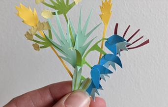 A picture of a close-up of some paper flowers, held in someone's hand