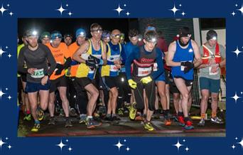 A picture of a group of runners about to set off on a nighttime run. All are wearing head torches.