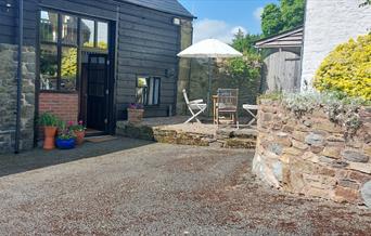 Outside of Granary Cottage, with parking space, Pretty terrace with tables, chairs and sunshade