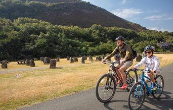 Family on bikes in front of dam wall at Elan Valley