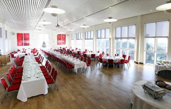 Medrus Mawr Conference Room set up with rows of tables set up for a formal dinner.